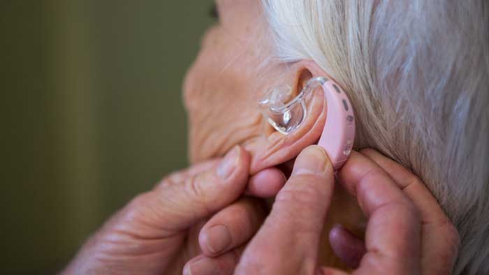 Person is adjusting hearing aid